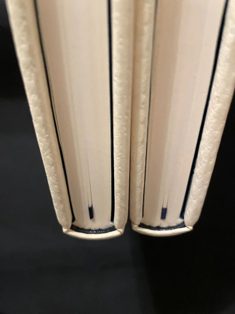 Two Claimed binding prototypes in cream leather, seen from the head, with leather endbands