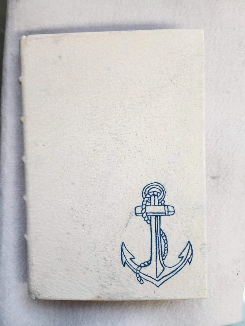 A Claimed binding prototype in cream leather with a tattooed anchor on the front board