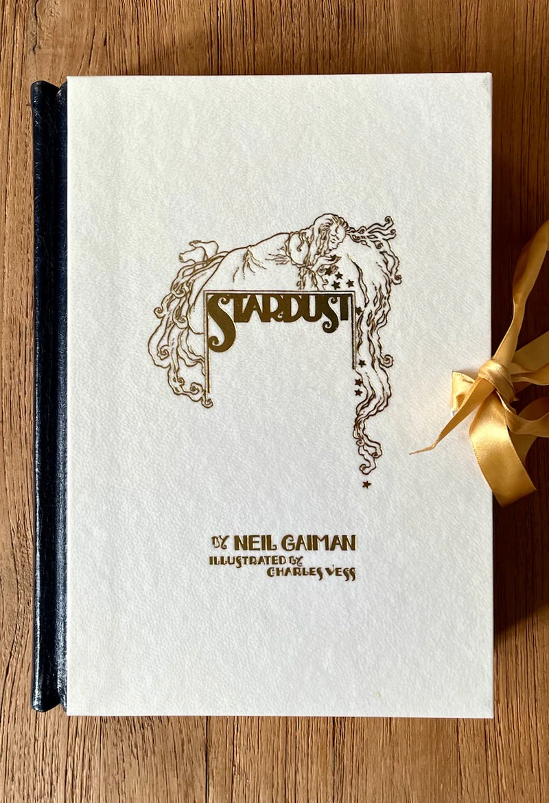 The lettered Stardust from Lyra's Books: cream vellum front board stamped in gold, tied with a gold ribbon